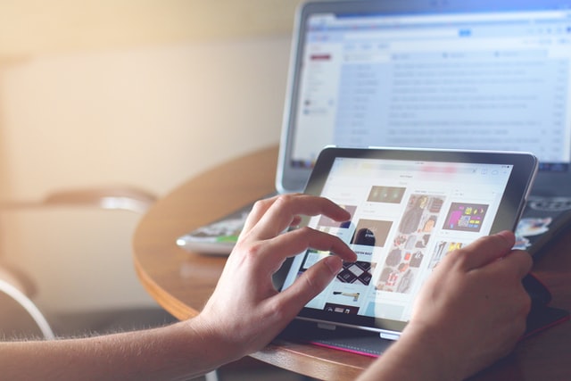 A person looking at pictures on a tablet. 