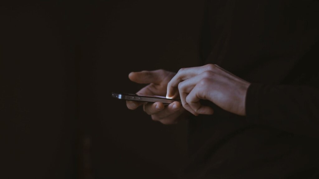 7 Time Management and Productivity Tips for Web Designers 3 A person who is preoccupied with their phone.